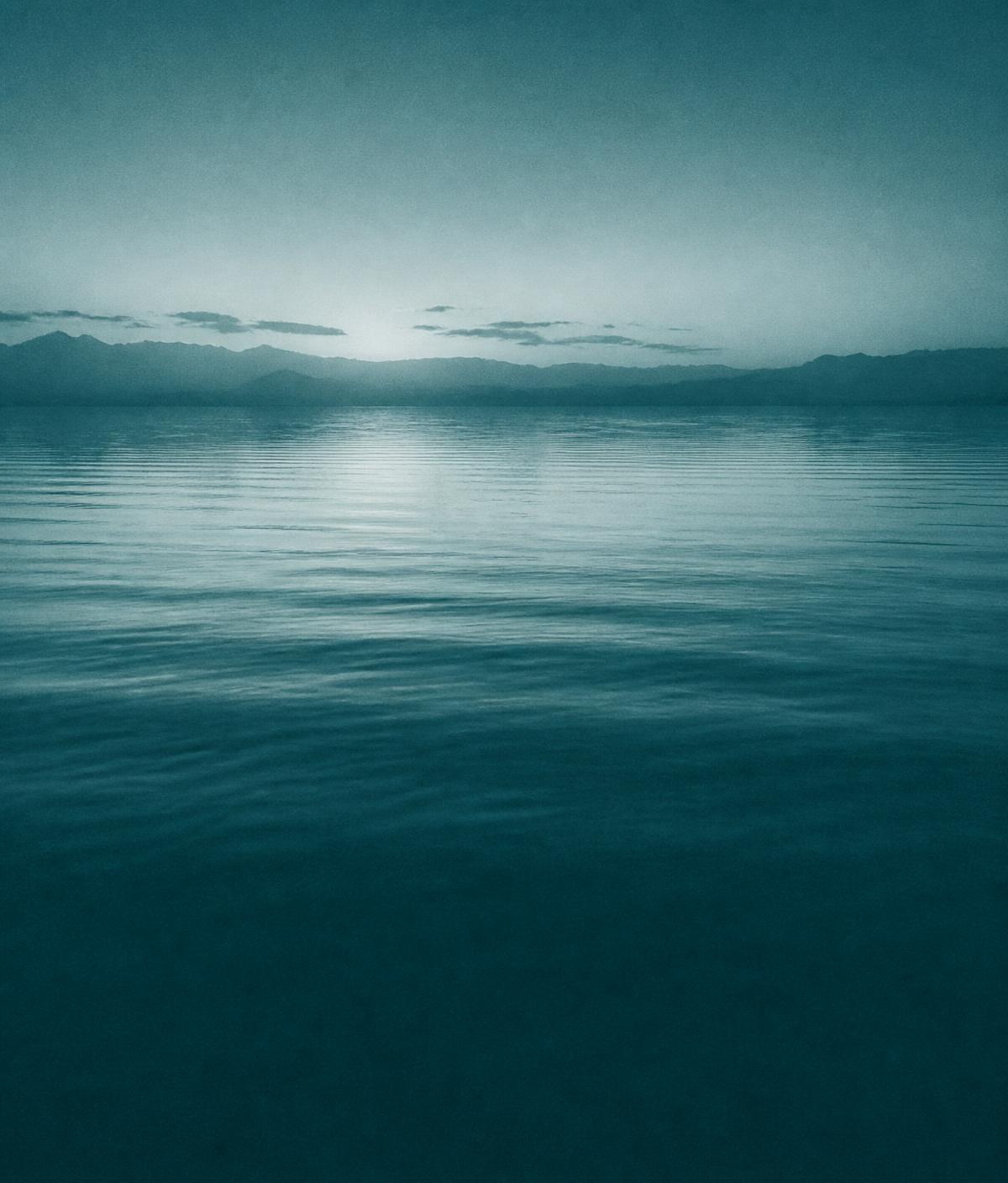 Still water surface at dawn with soft ripples